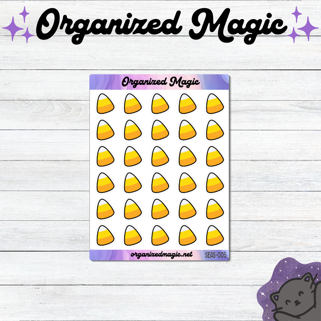 A sheet of planner stickers featuring a grid of yellow, orange, and white candy corn illustrations on a white background with purple header and footer bands. The sheet is displayed on a white wood-plank surface, with the brand name 'Organized Magic' printed at the top of the image and a small purple cat illustration in the bottom right corner.