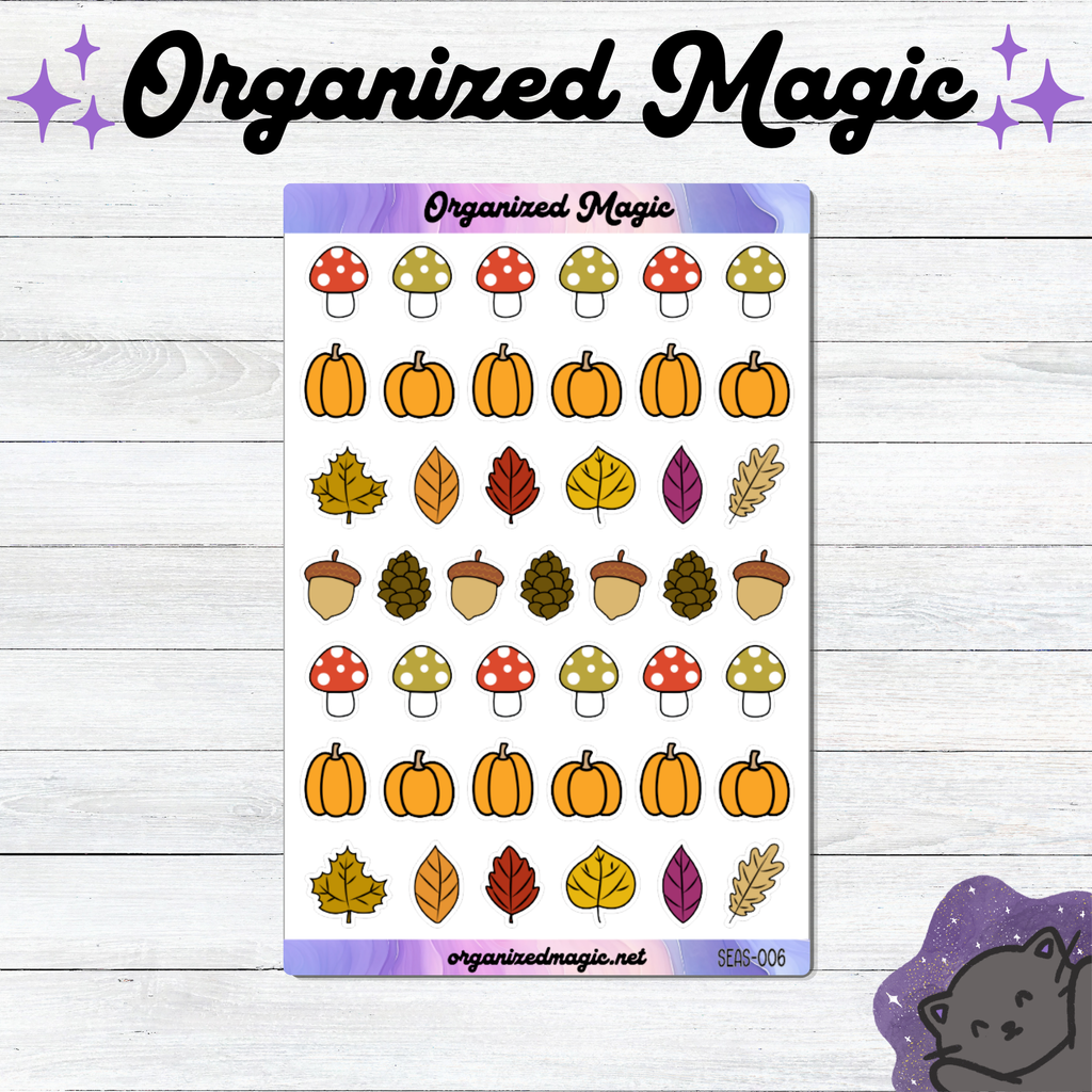 A sticker sheet titled 'Organized Magic' featuring autumn-themed illustrations including pumpkins, leaves, acorns, and mushrooms, displayed on a white wood background with decorative text and a cat illustration.