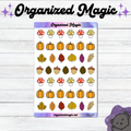 A sticker sheet titled 'Organized Magic' featuring autumn-themed illustrations including pumpkins, leaves, acorns, and mushrooms, displayed on a white wood background with decorative text and a cat illustration.