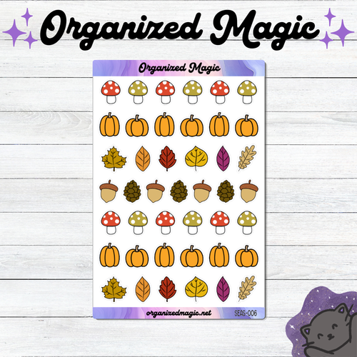 A sticker sheet titled 'Organized Magic' featuring autumn-themed illustrations including pumpkins, leaves, acorns, and mushrooms, displayed on a white wood background with decorative text and a cat illustration.
