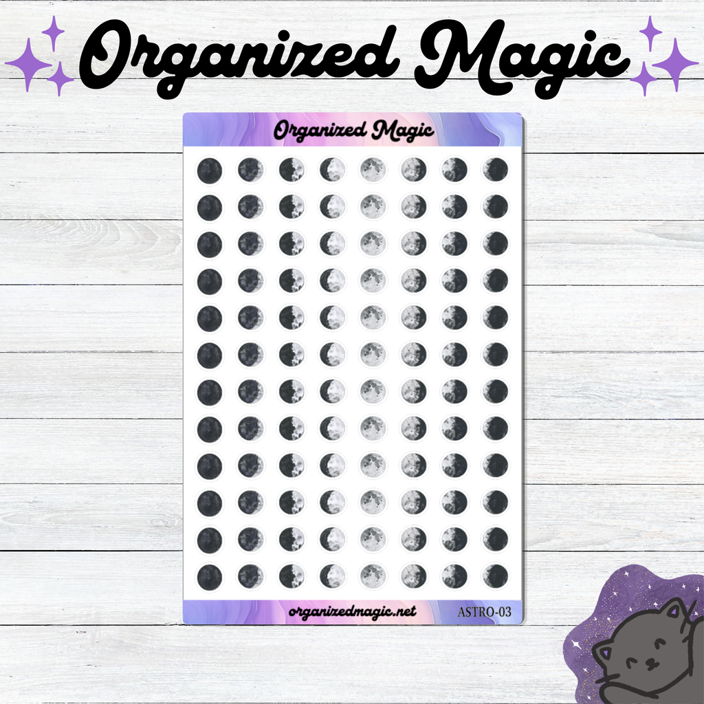 A sheet of small moon phase planner stickers displayed on a white wood background, with decorative text reading 'Organized Magic' at the top and a small cat illustration in the bottom right corner.